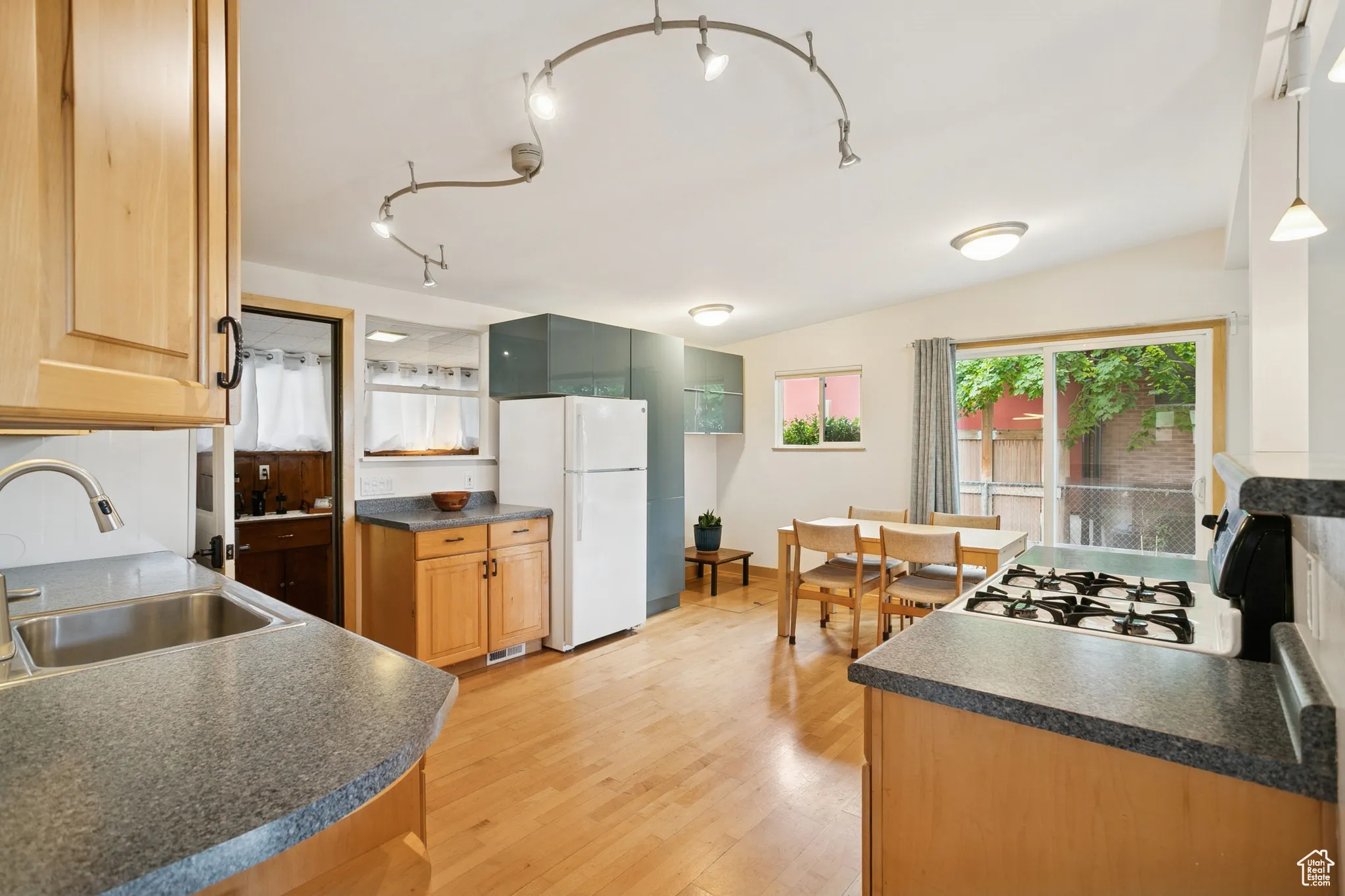 Kitchen featuring dark countertops, plenty of natural light, freestanding refrigerator, and light wood-style floors