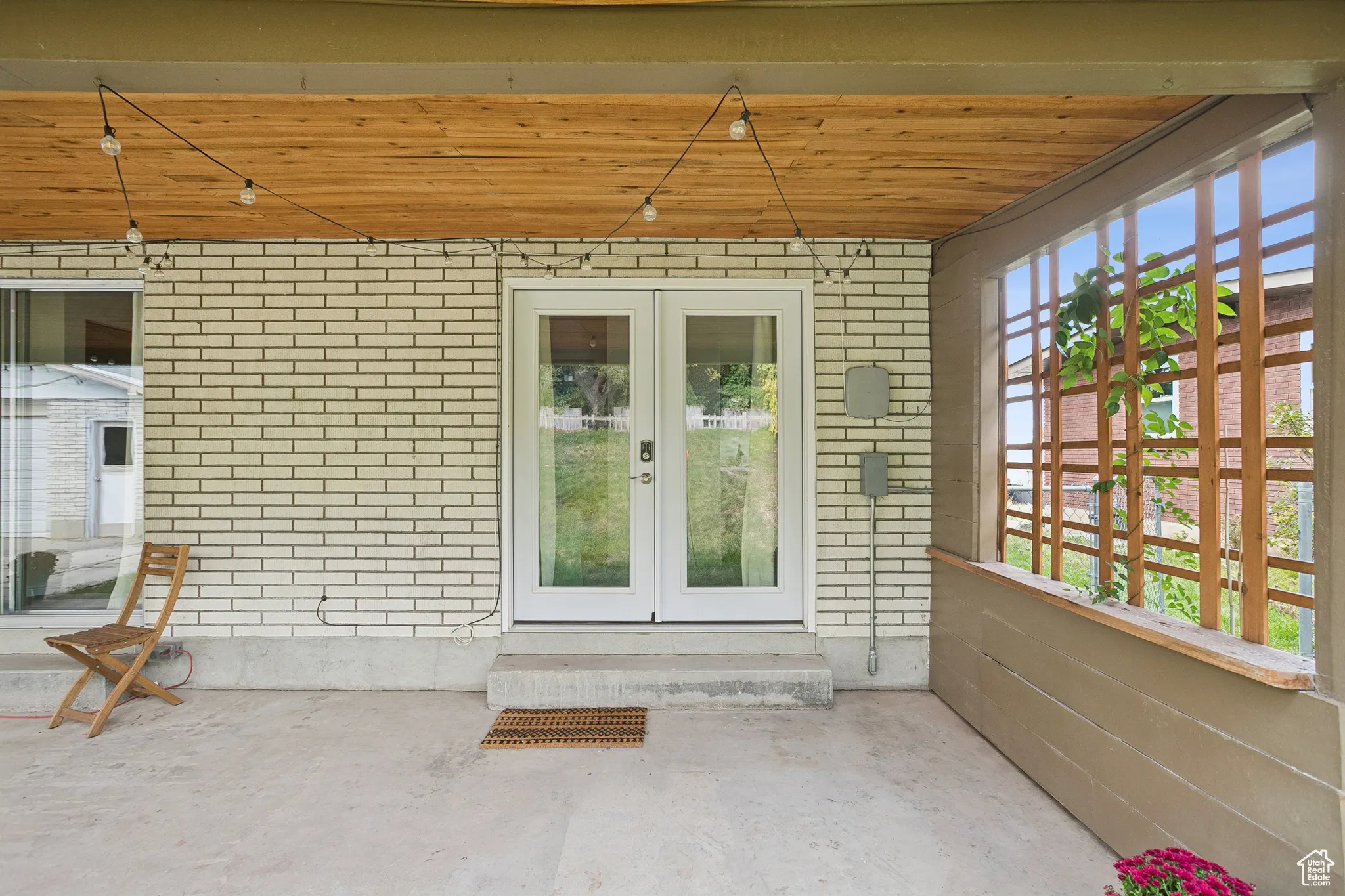Entrance to property with brick siding, french doors, and a patio