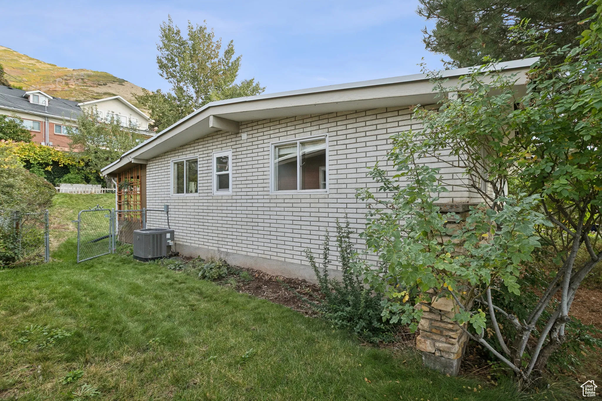 View of side of property featuring brick siding and a gate