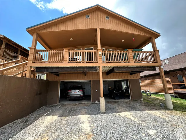 Rear view of house with driveway and a carport