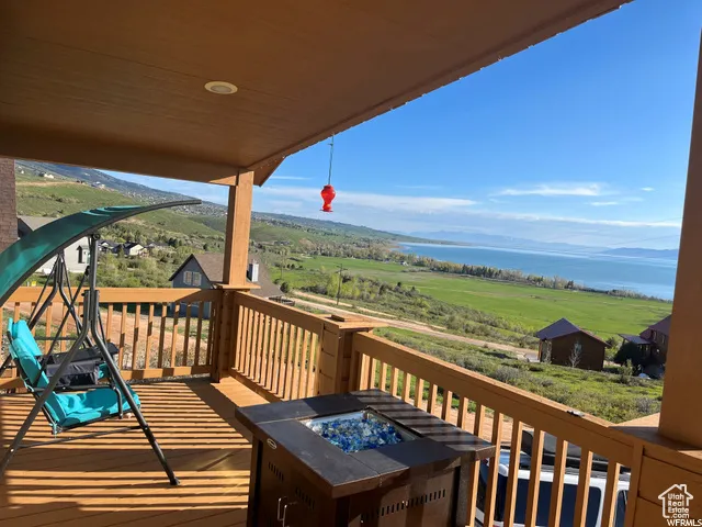 Deck with a fire pit, a water view, and a view of countryside