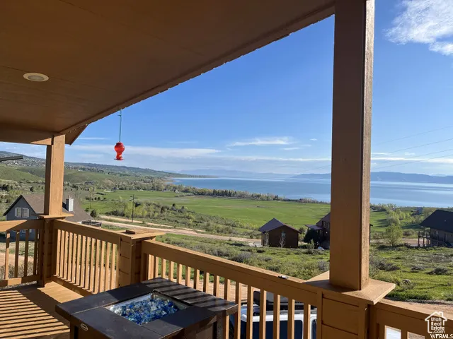Deck with a fire pit, a water view, and a view of countryside