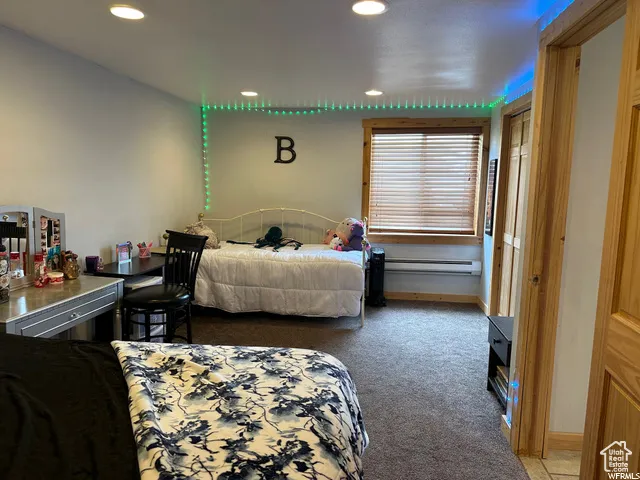 Bedroom featuring light carpet, recessed lighting, and baseboard heating