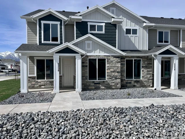 Craftsman house with board and batten siding, stone siding, and roof with shingles