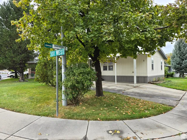 View of home's exterior featuring a lawn and driveway