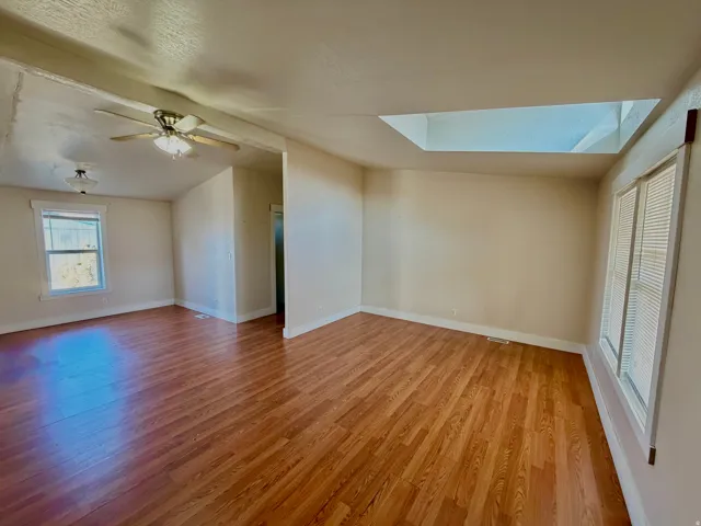 Unfurnished room featuring light wood-style flooring and a skylight