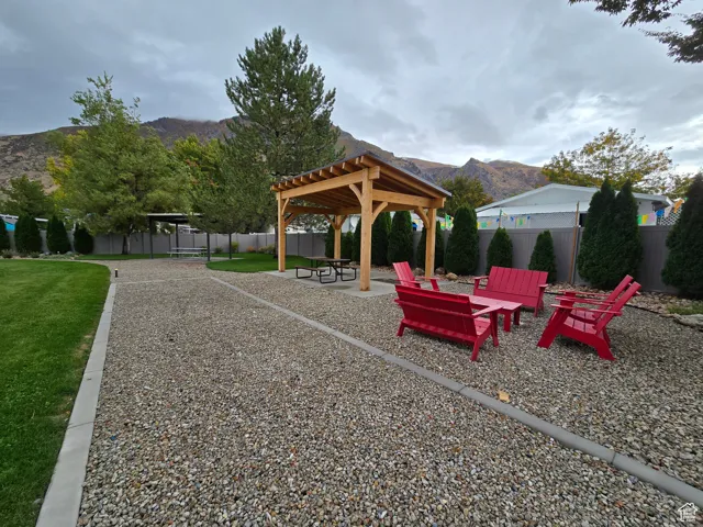 View of home's community with a mountain view, a patio, and a fenced backyard