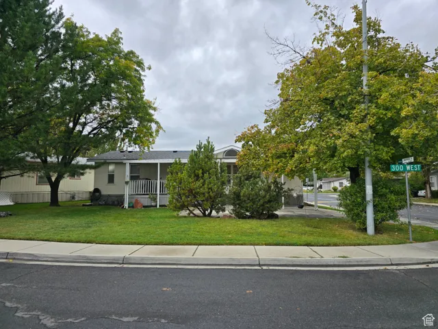 View of front of house featuring a front lawn and covered porch