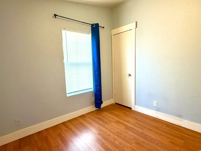 Empty room with light wood-style flooring and baseboards