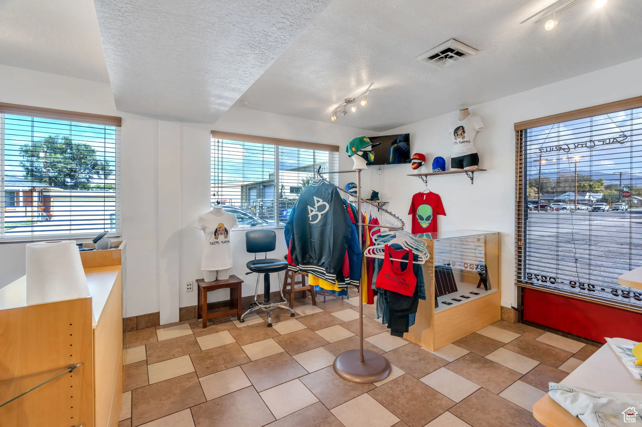 Bedroom featuring rail lighting, multiple windows, and a textured ceiling