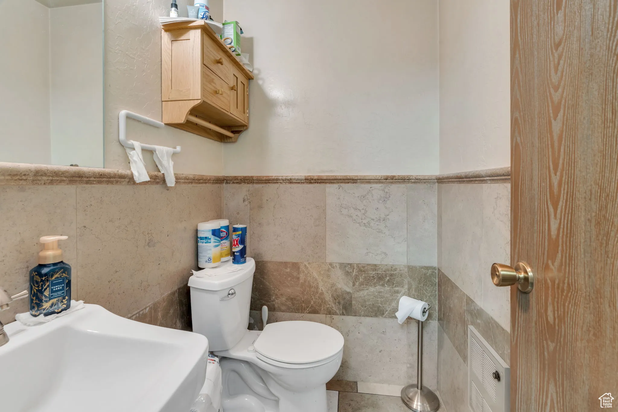 Half bathroom with tile walls and wainscoting