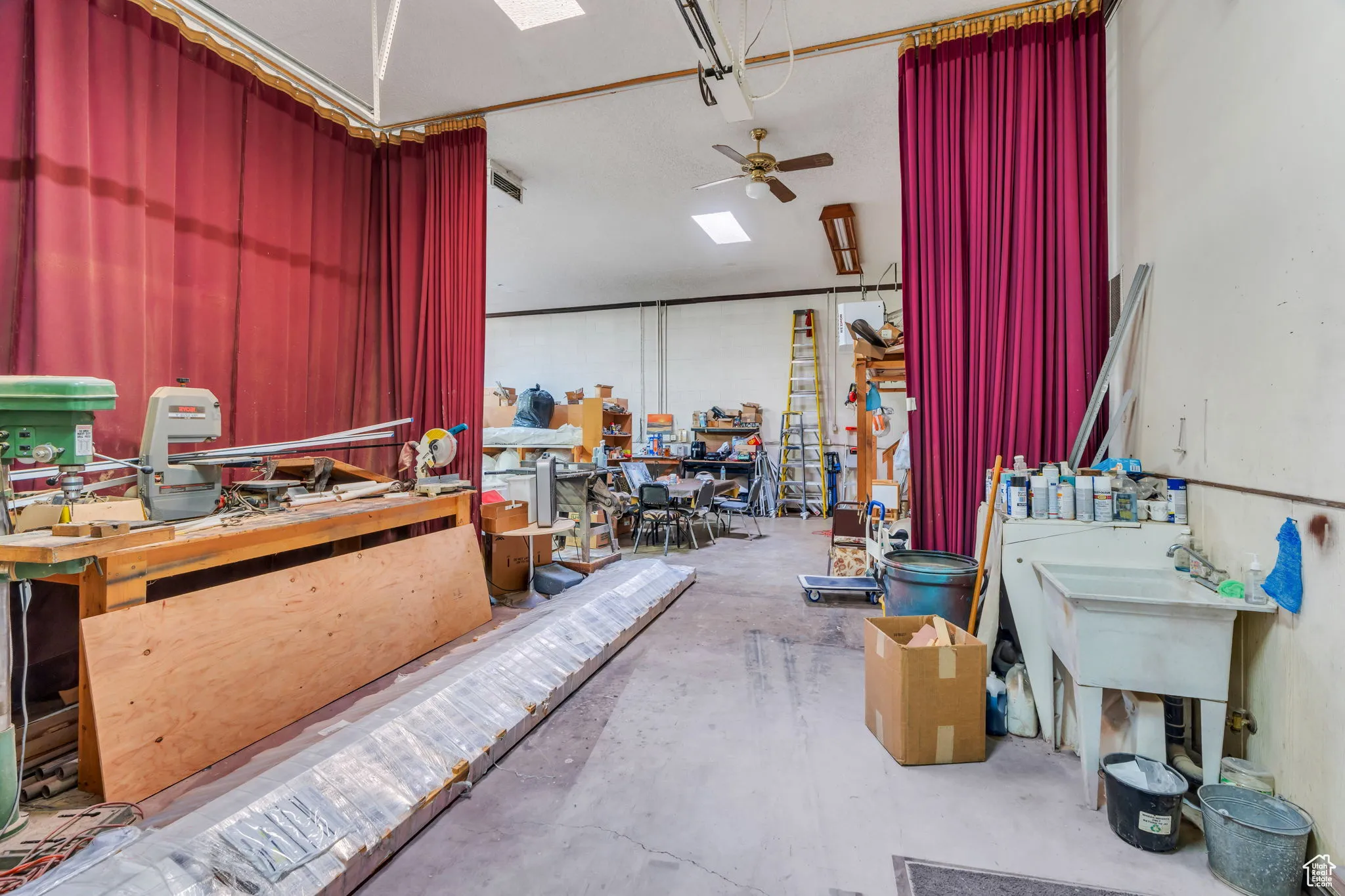 Miscellaneous room featuring a workshop area, a skylight, and a ceiling fan