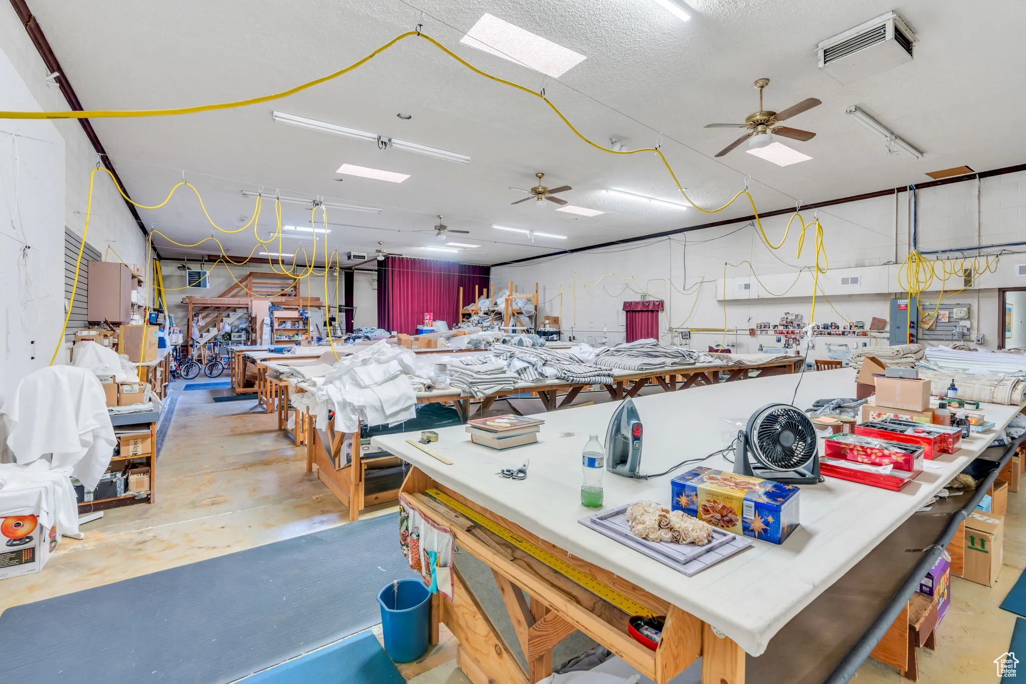 Miscellaneous room featuring ceiling fan, a workshop area, a skylight, and electric panel