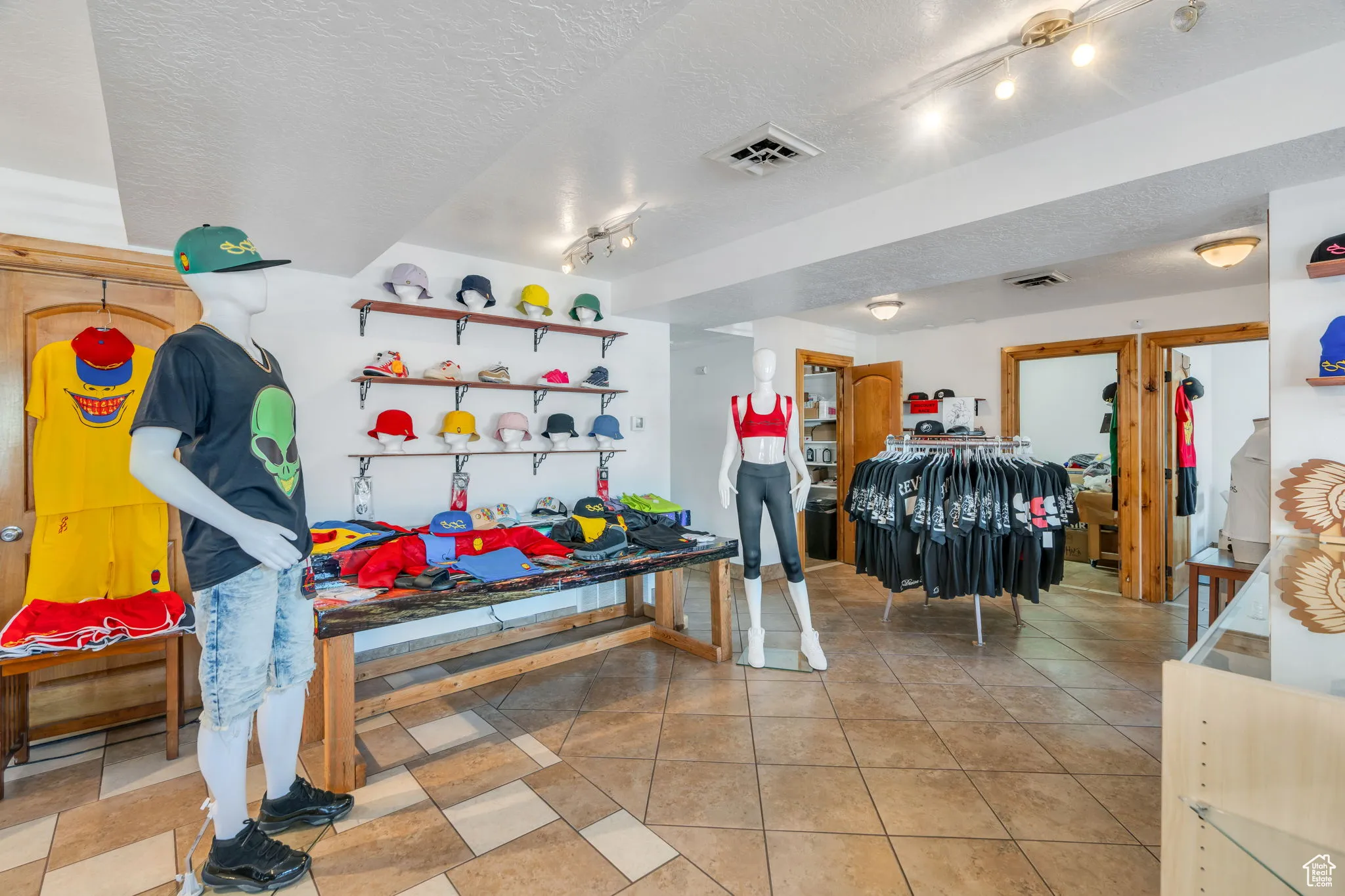 Playroom featuring a textured ceiling, light tile patterned flooring, and track lighting