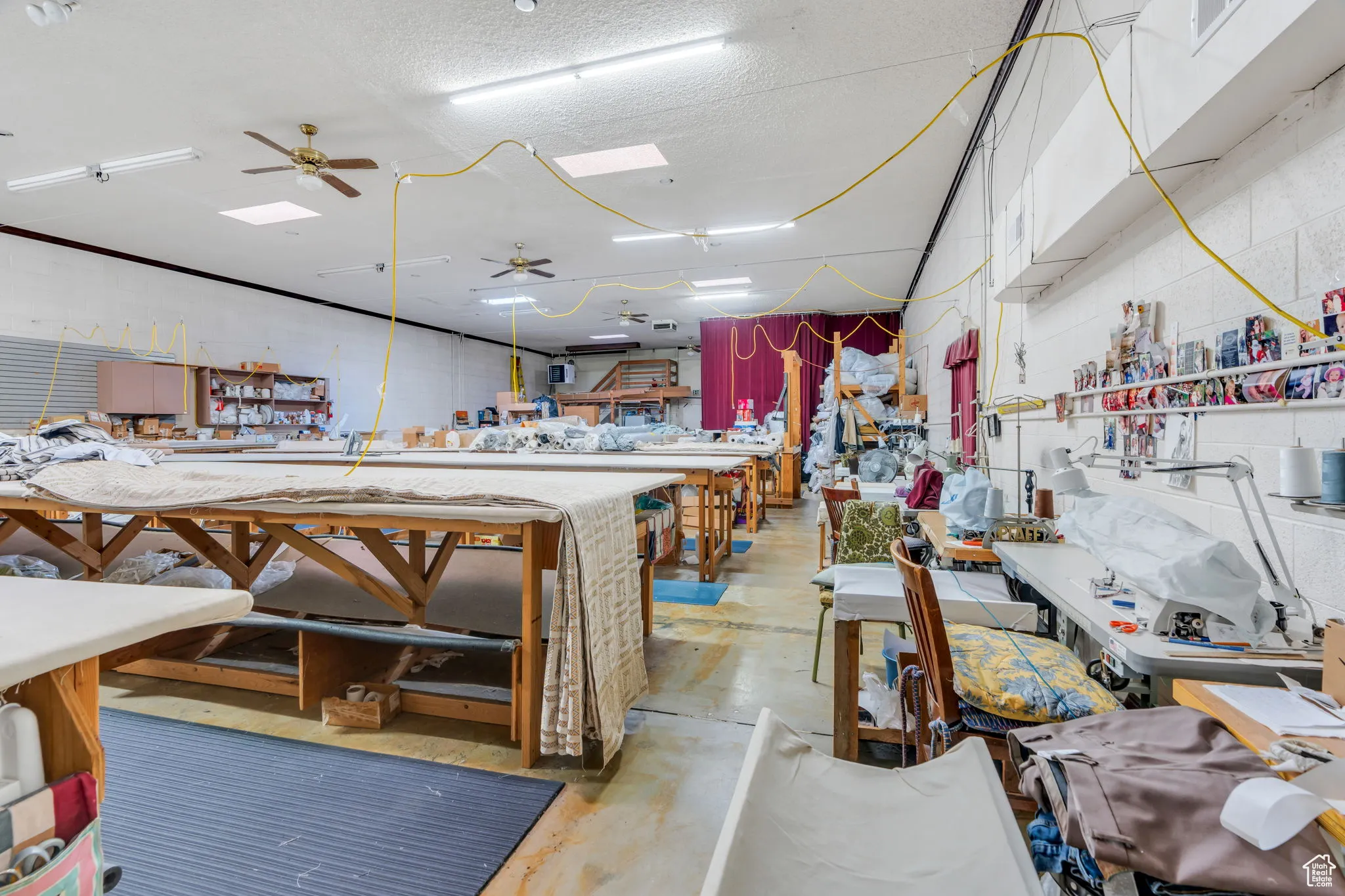 Miscellaneous room with a ceiling fan, a workshop area, and a textured ceiling