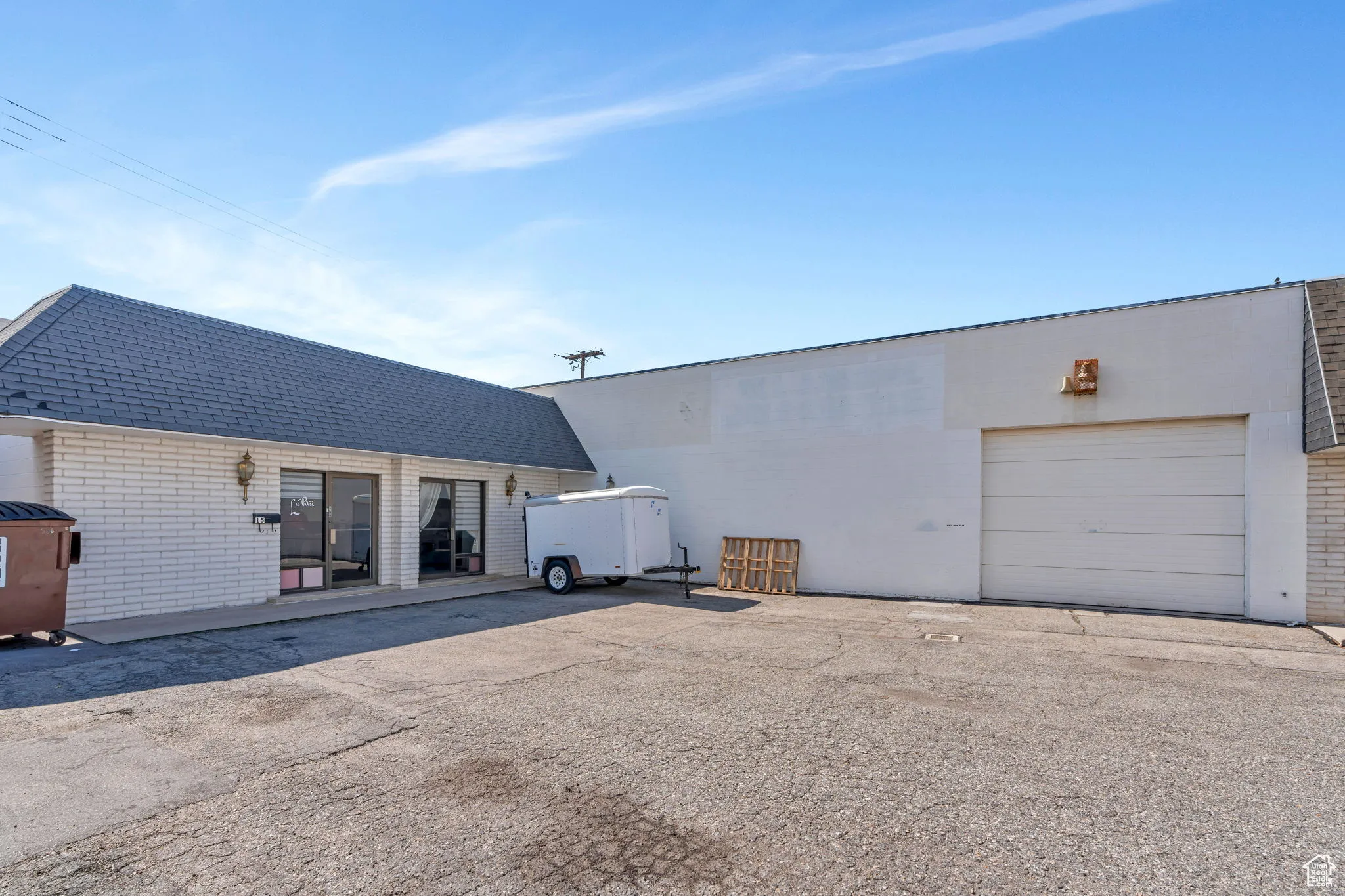 View of property exterior featuring brick siding, a garage, and driveway