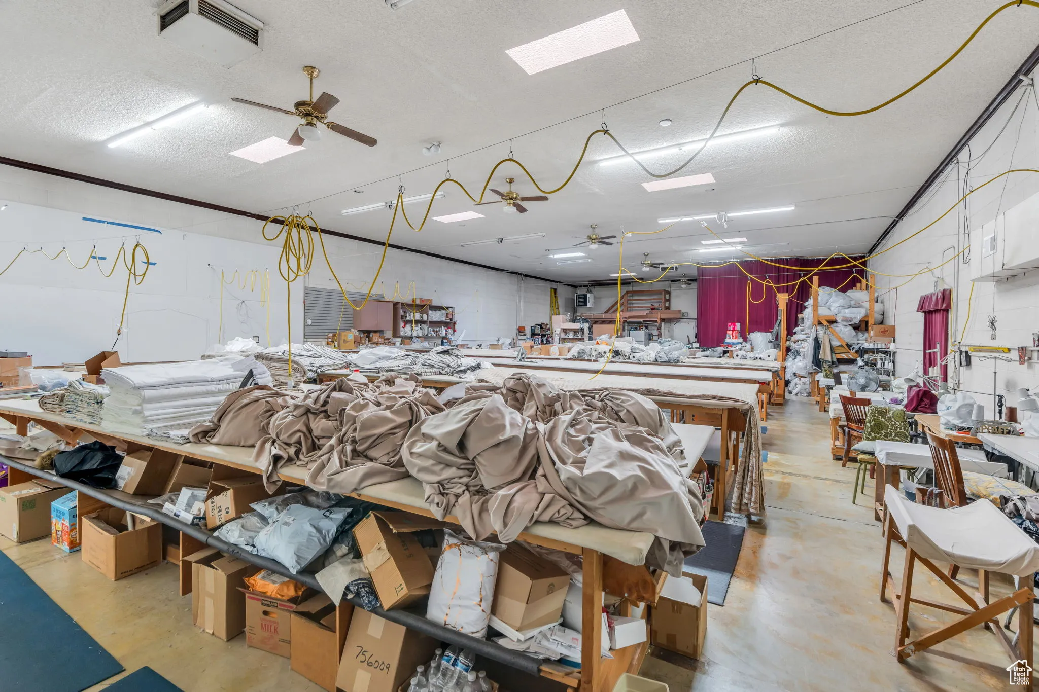 Miscellaneous room with a ceiling fan, a workshop area, and a textured ceiling