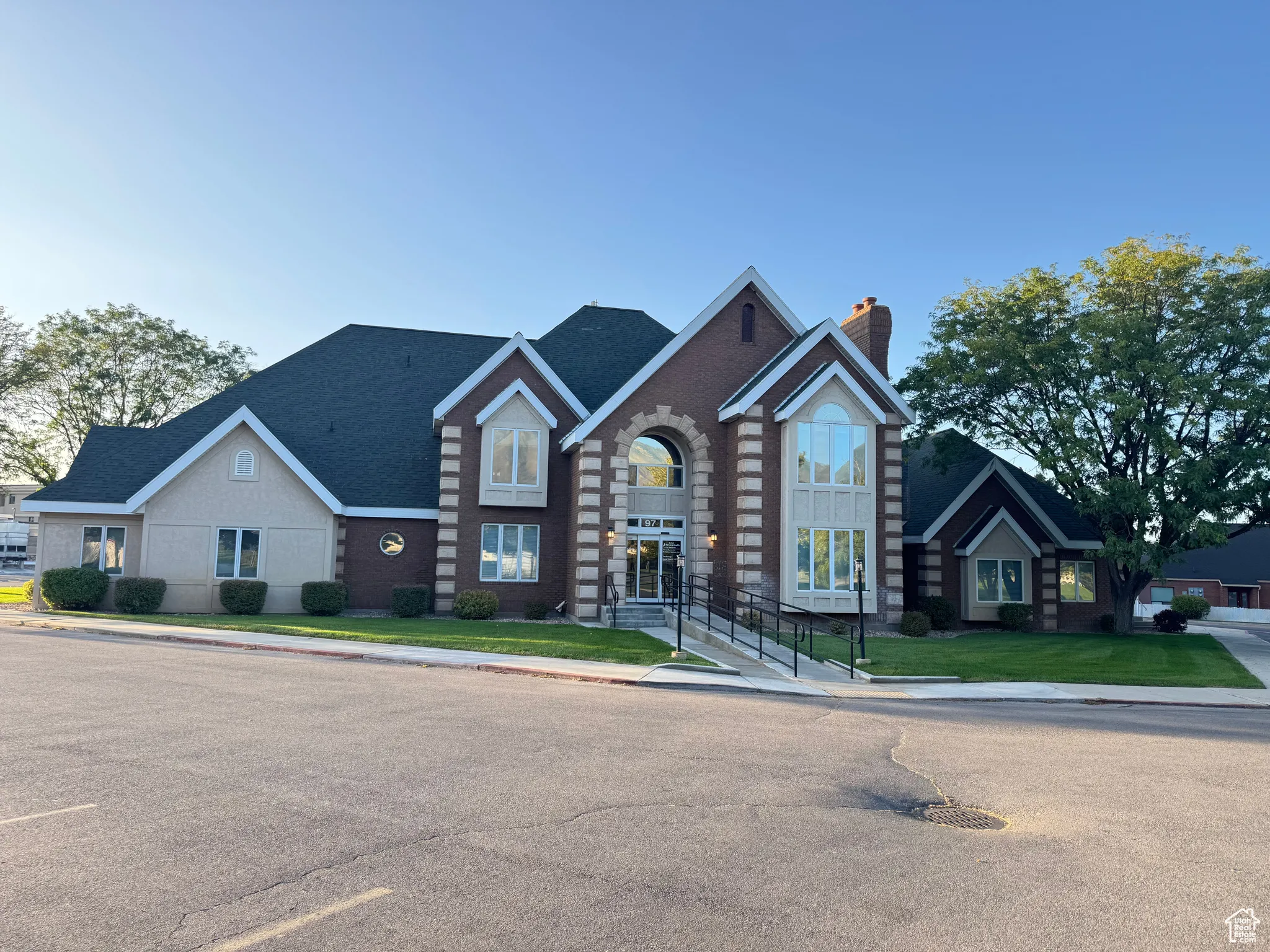 Traditional-style house featuring a chimney, a front yard, and brick siding