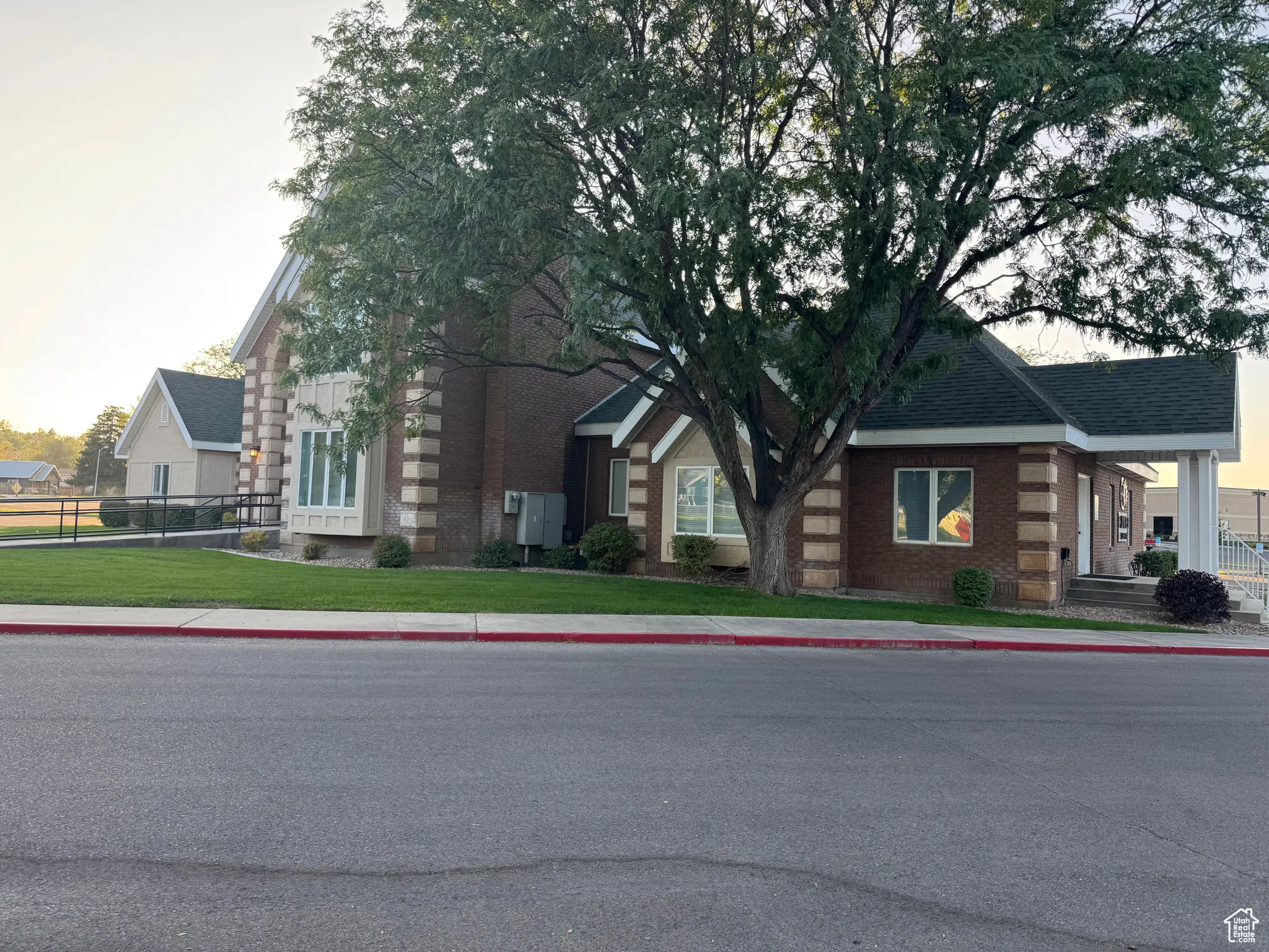 View of front of home featuring brick siding and roof with shingles