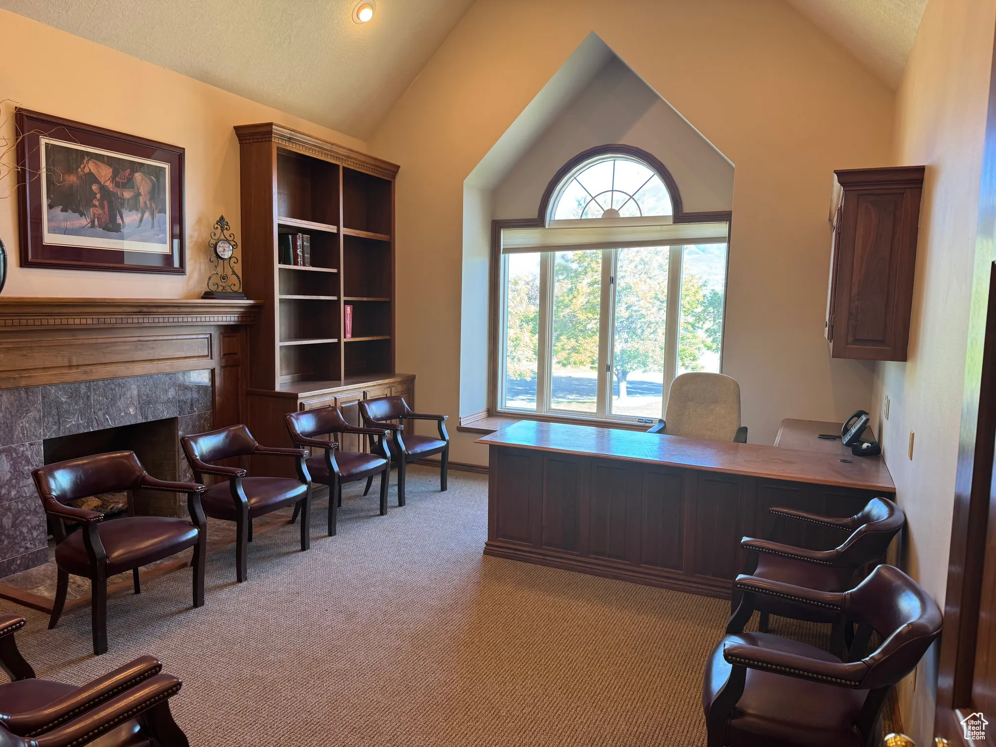 Office featuring lofted ceiling and a high end fireplace
