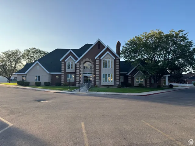 Medical Office Building: View of front of property with a chimney, uncovered parking, and a front yard