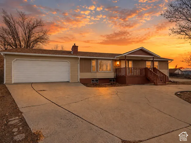 Single-story residence featuring a two-car garage, front porch with railings, and a concrete driveway
