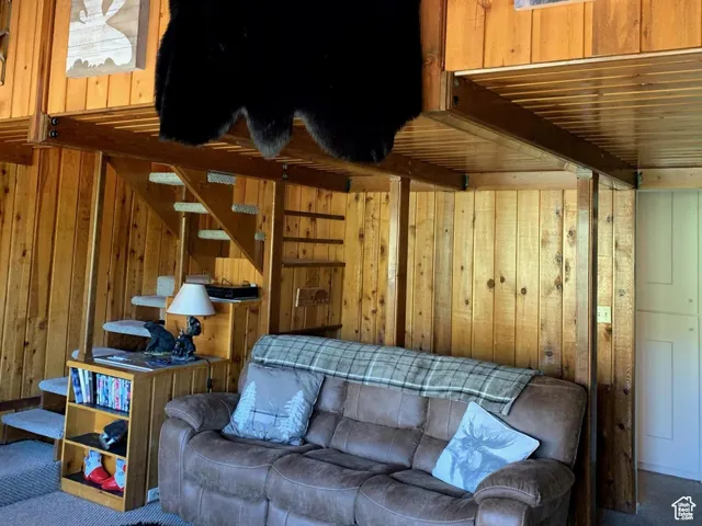 Living room with carpet floors and wood walls
