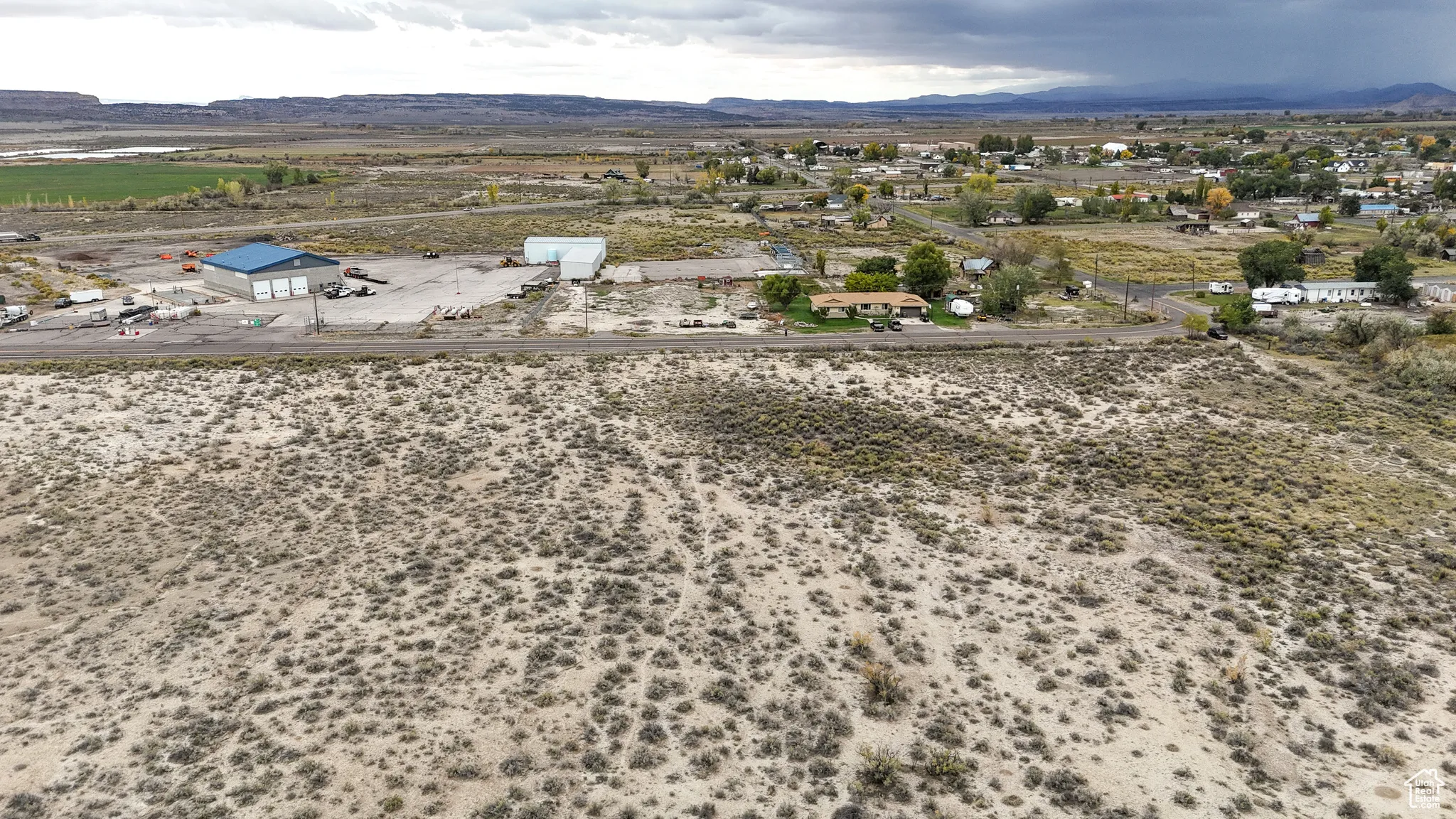 Aerial view of sparsely populated area featuring a mountain backdrop and a desert landscape