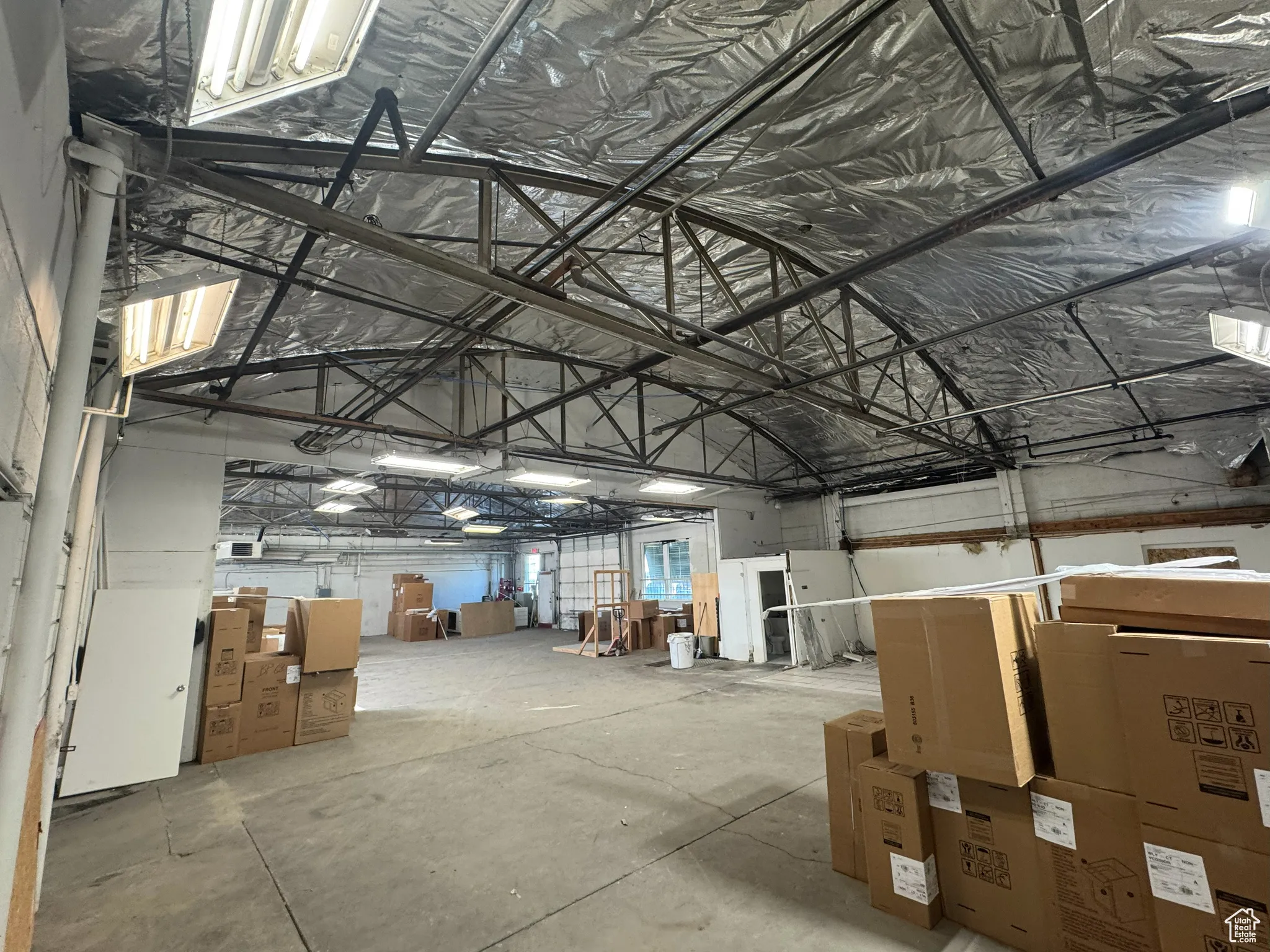 Misc room featuring lofted ceiling, a garage, and metal wall