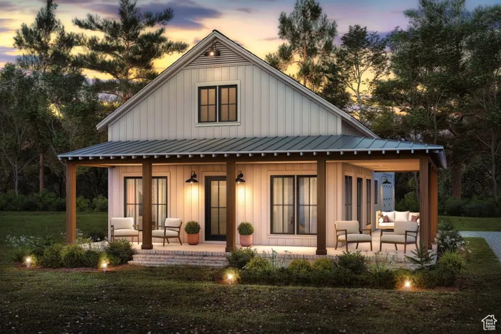 Rear view of house with board and batten siding, an outdoor living space, covered porch, and a yard