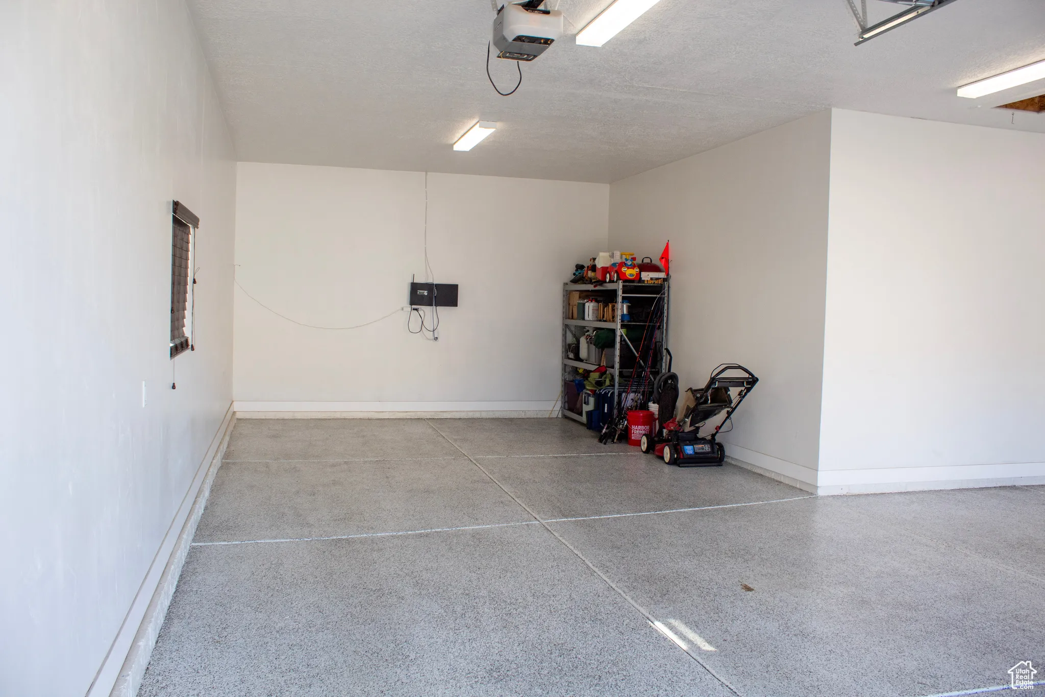 Garage featuring baseboards and a garage door opener