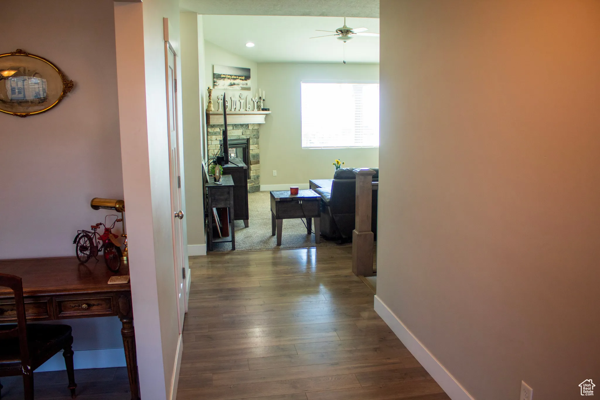 Corridor featuring dark wood-style flooring and a desk
