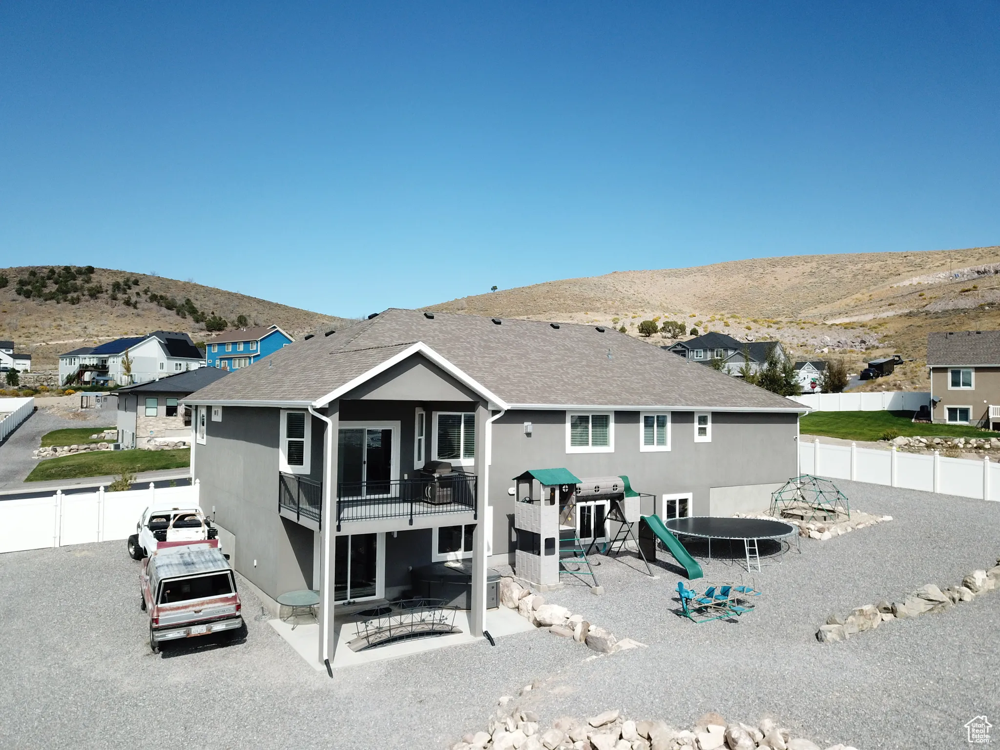 Back of property with a trampoline, a fenced backyard, a patio area, and a mountain view