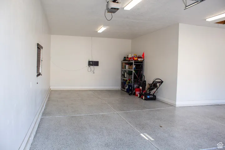 Garage featuring baseboards and a garage door opener
