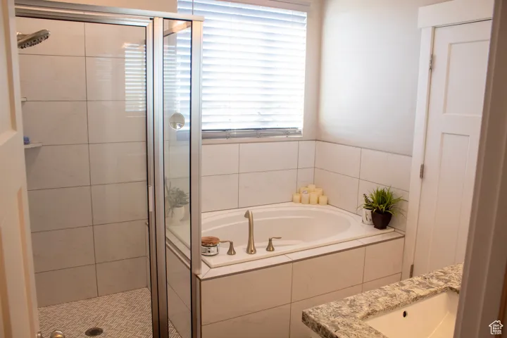 Full bathroom with a shower stall, a bath, and vanity