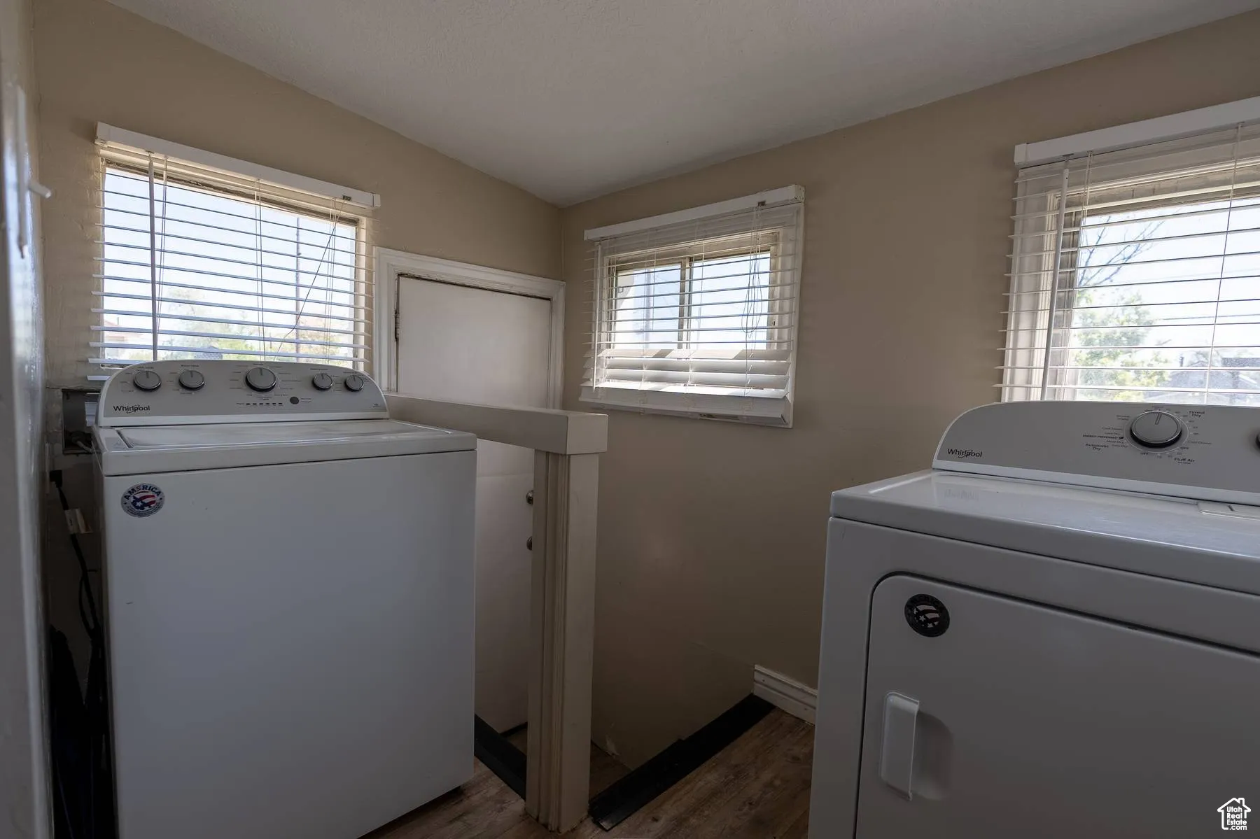 Laundry area featuring light wood finished floors and washing machine and dryer