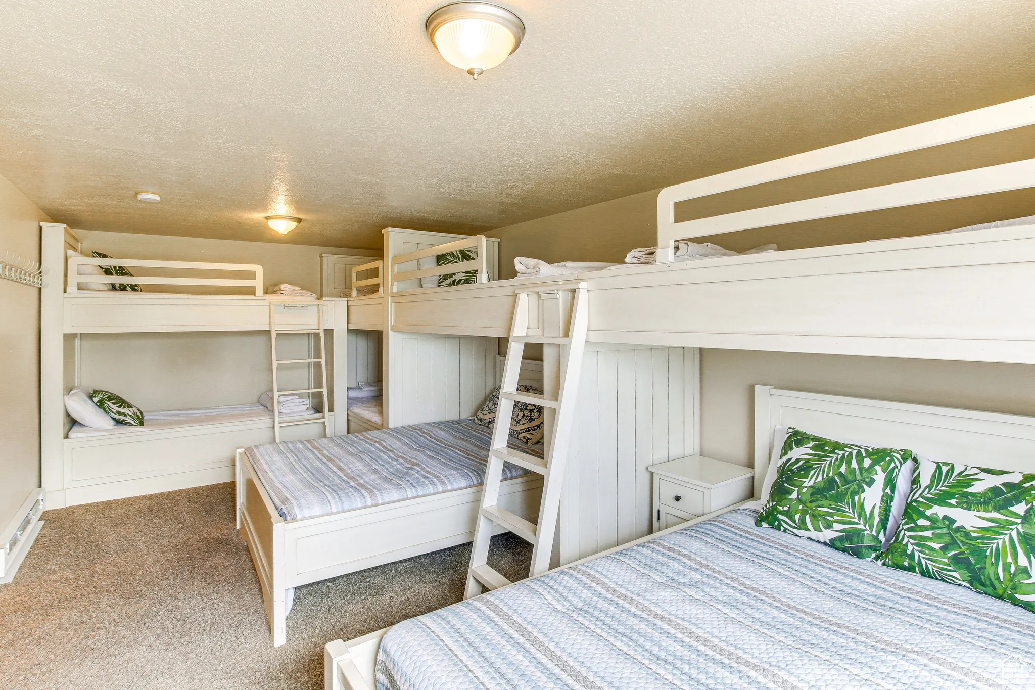 Bedroom with a textured ceiling, carpet, and baseboard heating