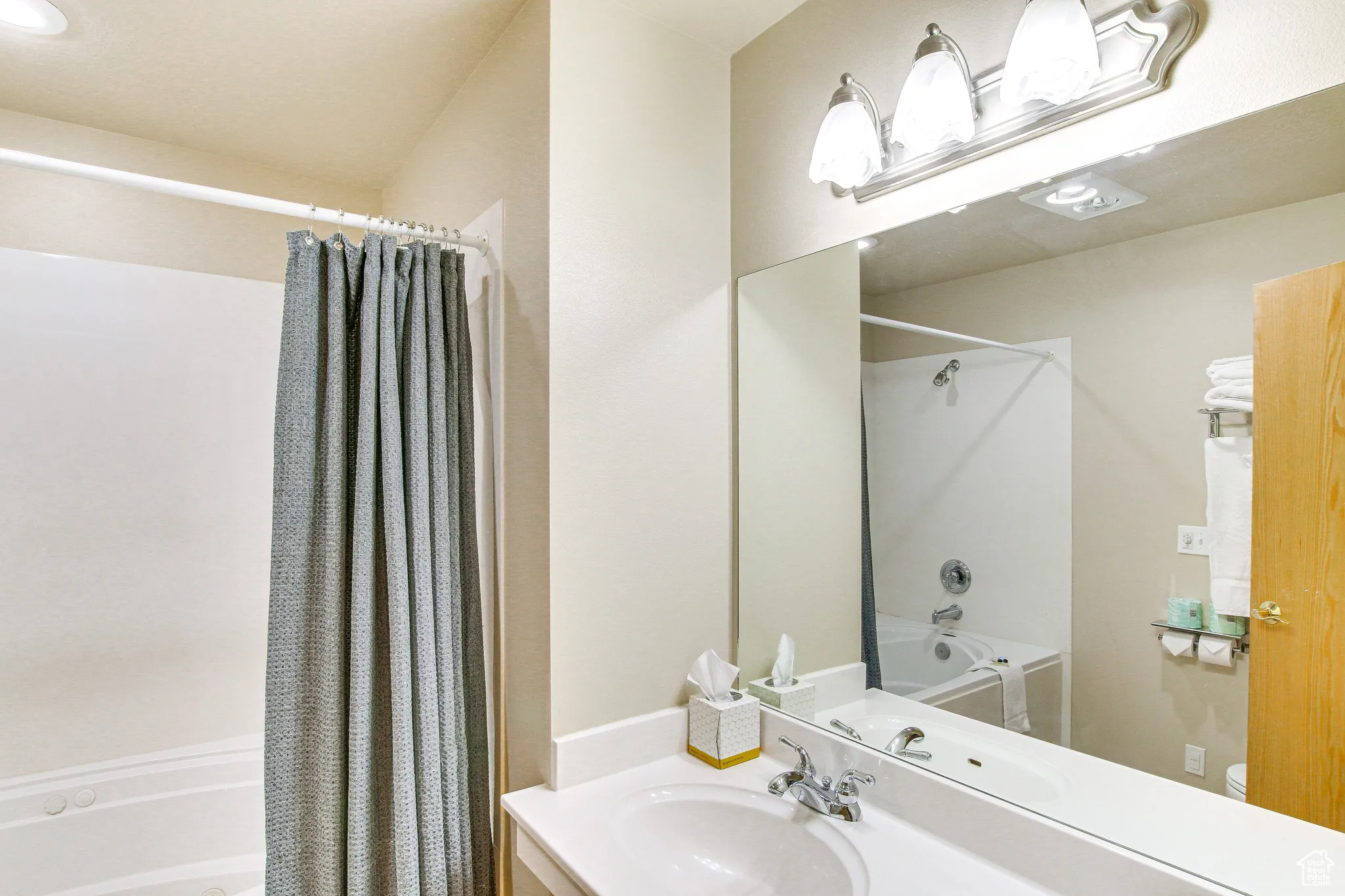 Bathroom featuring shower / bath combination with curtain and vanity