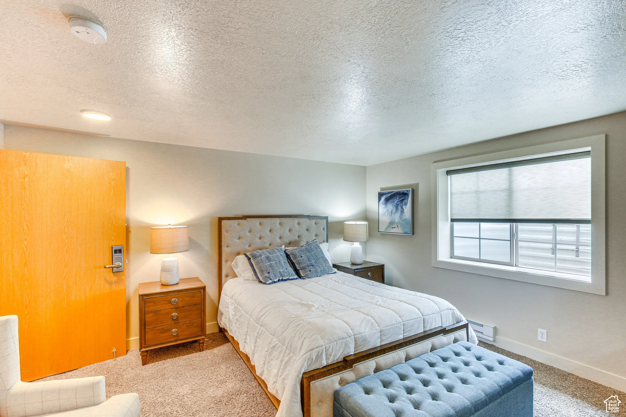 Bedroom featuring a textured ceiling, carpet floors, and a baseboard radiator