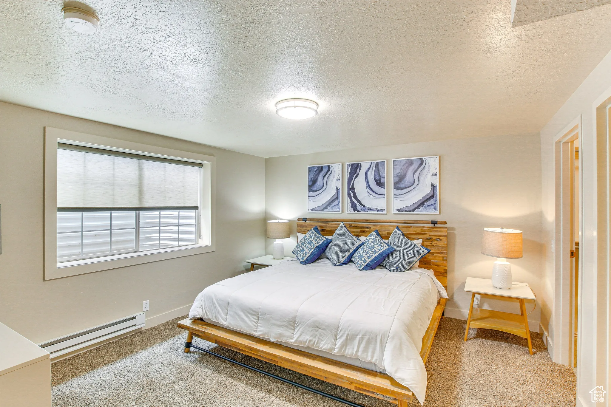 Bedroom featuring carpet flooring, a textured ceiling, and baseboard heating