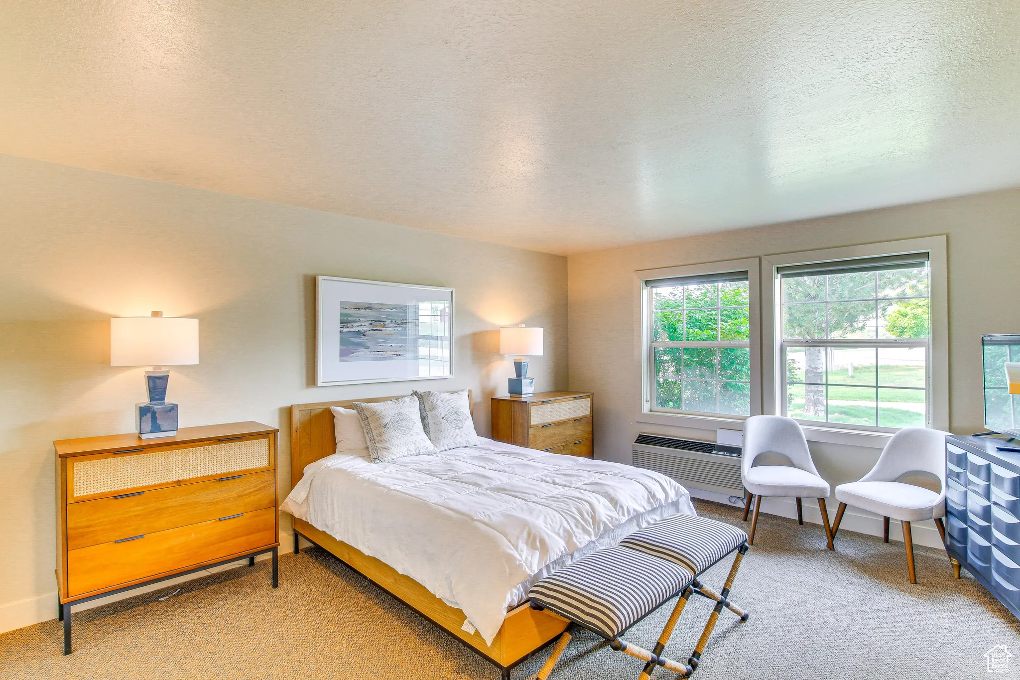 Bedroom with light colored carpet and a textured ceiling