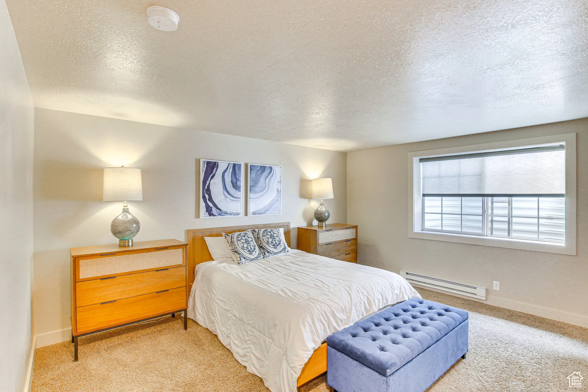 Bedroom featuring a textured ceiling, carpet flooring, and a baseboard radiator