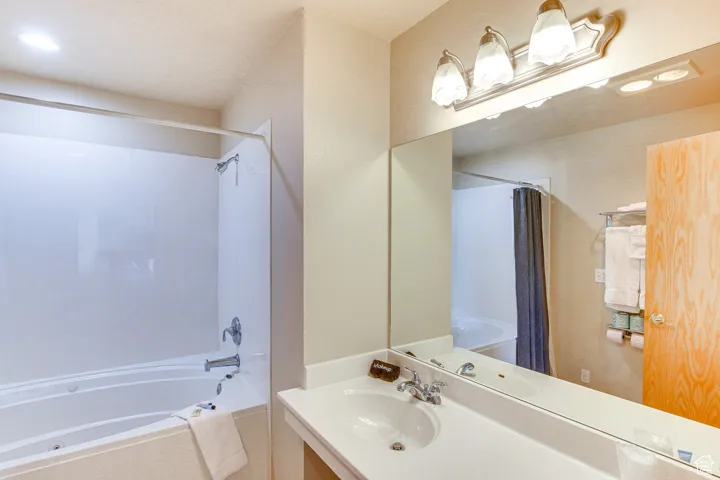 Full bath featuring shower / bathtub combination with curtain, recessed lighting, and vanity