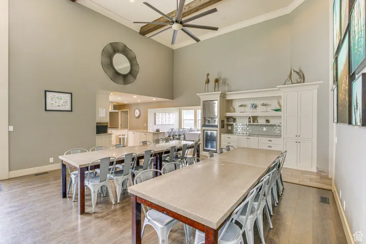 Dining room with a towering ceiling, light wood-style flooring, recessed lighting, ceiling fan, and ornamental molding
