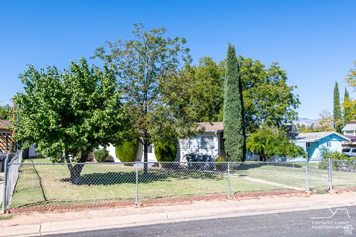 View of property hidden behind natural elements featuring a fenced front yard