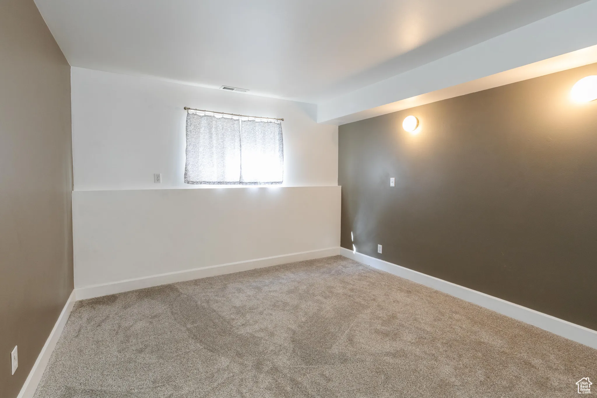 Unfurnished room with light carpet and baseboards