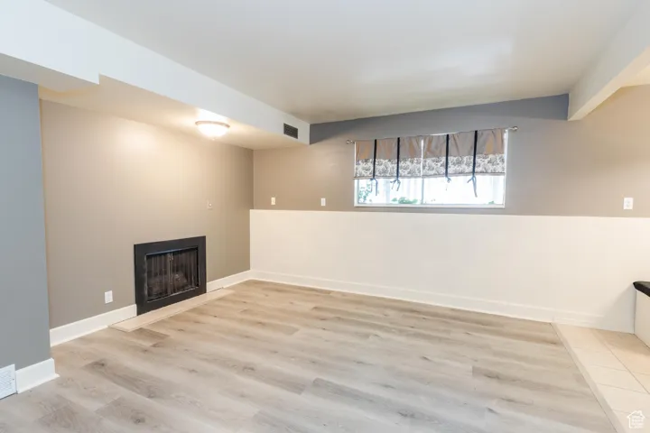 Basement featuring a fireplace and light wood-style floors