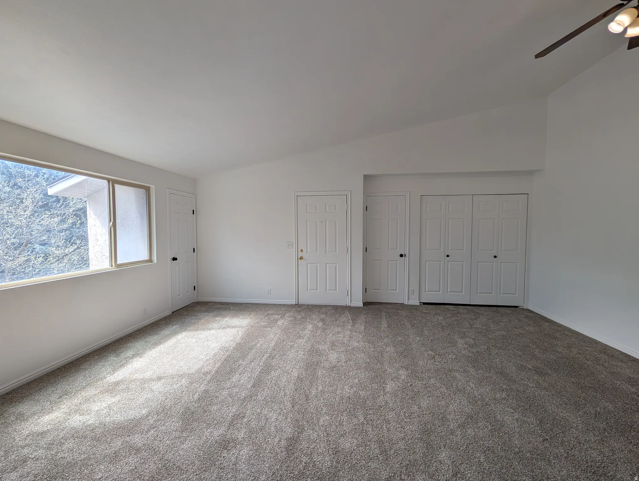 Unfurnished bedroom featuring carpet floors, a closet, and lofted ceiling