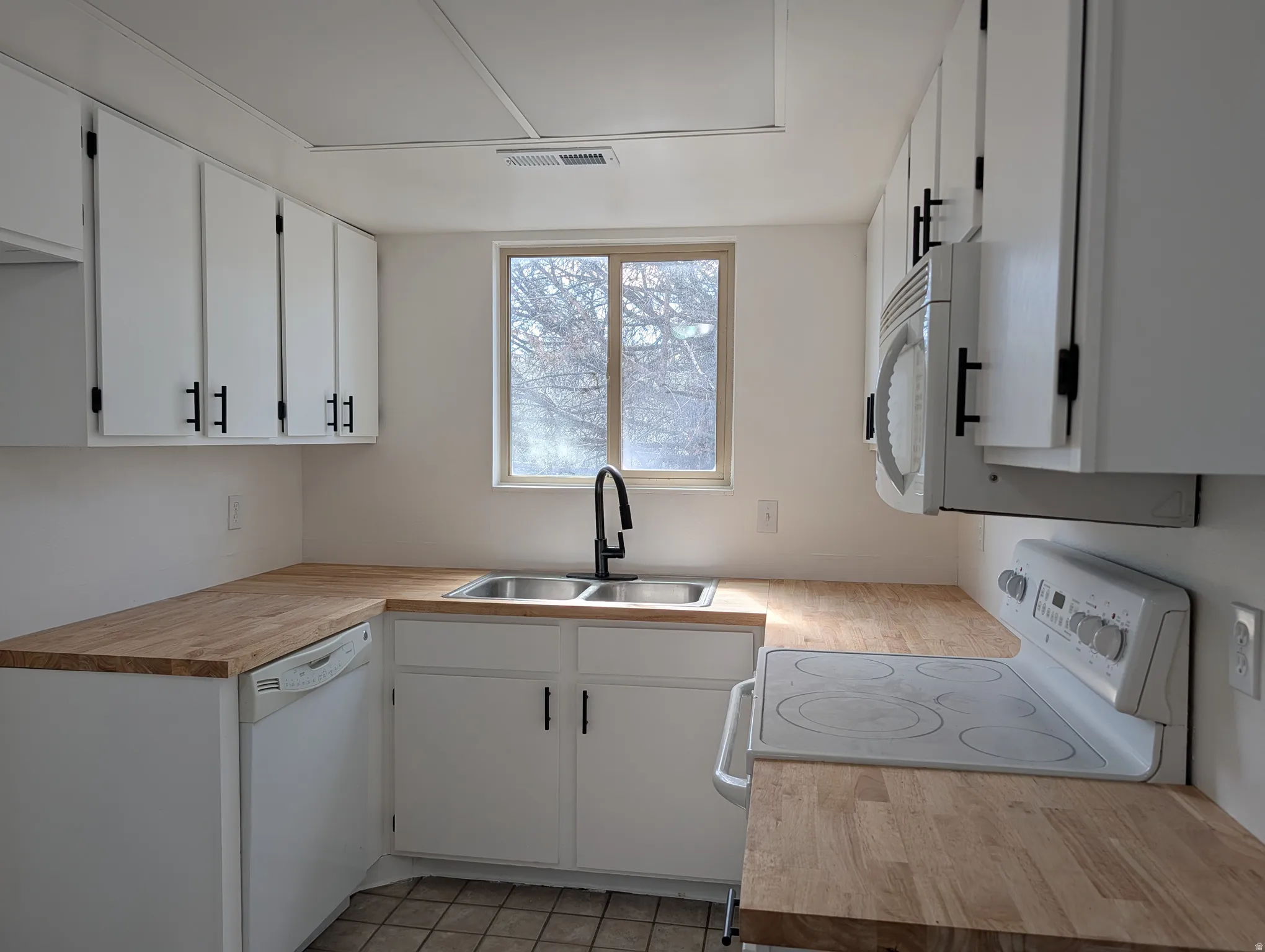 Kitchen with white appliances and white cabinetry
