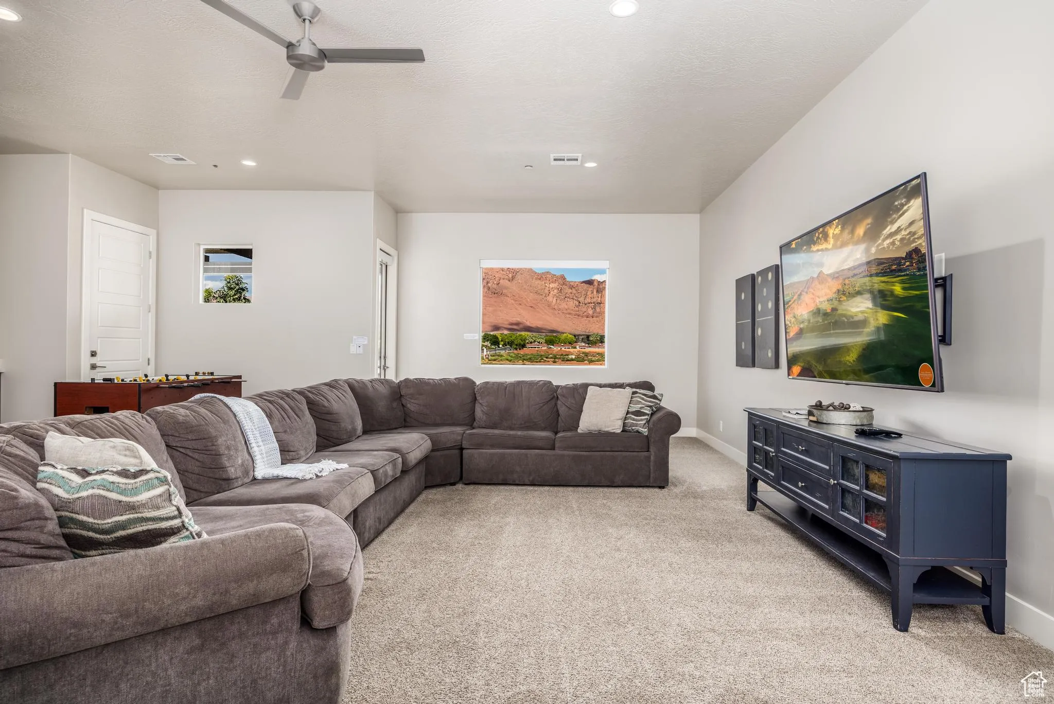 Living area featuring light carpet, recessed lighting, and a ceiling fan